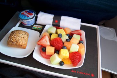 Toronto, Kanada - 27 Ocak 2017: Hava Kanada Business Class uçak içi yemek, kahvaltı ile kesilerek taze meyve, kahve, yoğurt ve çörek