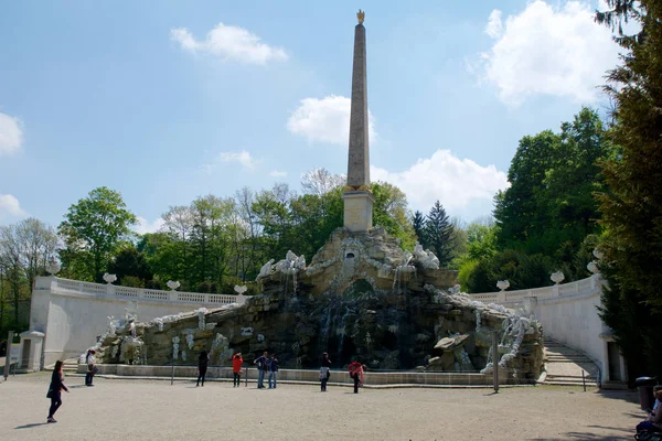 VIENNA, ÁUSTRIA - 30 de abril de 2017: Vista do Obelisco Fountain Obeliskbrunnen no parque público do Palácio Schonbrunn. Turista em pé em frente à fonte — Fotografia de Stock