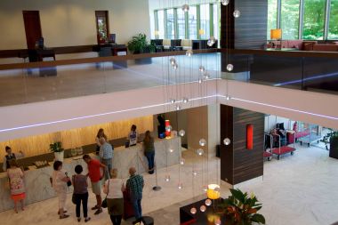 Mainz, Almanya - 8 Temmuz 2017: Modern iç mekanları, Hilton Mainz otel lobisinin sırada bekleyen insan ile