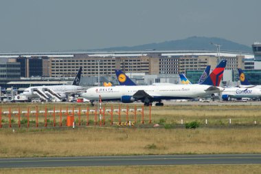 Frankfurt, Almanya - 09 Temmuz 2017: Kapı ve terminal binalarının varios uçaklar önünde Frankfurt Havaalanına ve bir Delta Hava Yolları'nın Jet kalkış için hazır
