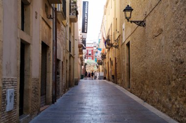 Tarragona, İspanya - 28 Ağustos 2017: Açık güneşli bir günde eski Avrupa şehir ıssız Sokağı. Parlak duvarları eski kasaba Tarragona, İspanya