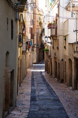 Tarragona, İspanya - 28 Ağustos 2017: Açık güneşli bir günde eski Avrupa şehir ıssız Sokağı. Parlak duvarları eski kasaba Tarragona, İspanya
