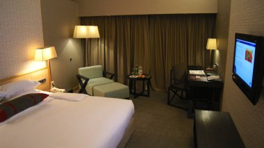 Singapur - 1 Nisan 2015: lüks modern iç, rahat bir yatak ve bir sandalye ile otel odasında