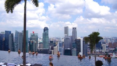 Singapur - 1 Nisan 2015: Çatı katındaki sonsuzluk havuzu insanlar nefes kesen manzaraları için rahatlatıcı ile Marina Bay Sands Skypark adlı
