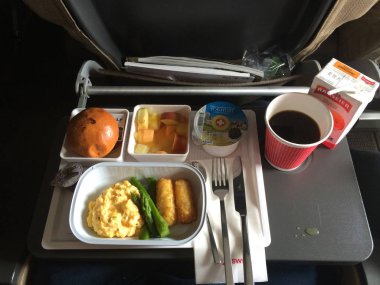 Zürih, İsviçre - 31 Mar 2015: Kahve, ezmesi, ekmek, yoğurt ve yumurta bir tepsi ile bir kahvaltı yemek, gemide bir uzun uçuş Singapur Ekonomi sınıfında