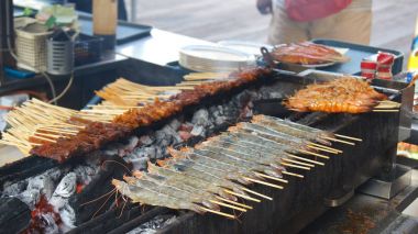 Singapur - 3 Nisan 2015: Lezzetli lezzetli şiş tavuk Cook Singapur'un Satay sokak gıda pazarında sıcak kömürlerin üzerinde