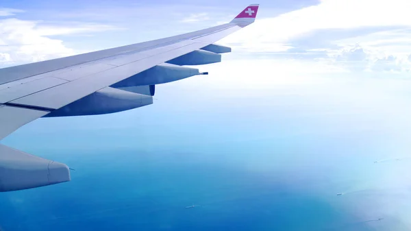 ZURICH, SWITZERLAND MAR 31, 2015: Wing View of an airplane during cloudy blue indigo sky — Stok Foto