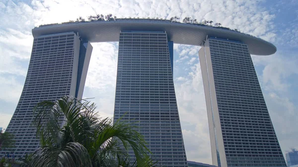 Singapore - Apr 1, 2015: Het Marina Bay Sands Resort in Singapore. De daken van de torens zijn ingericht met een park in de vorm van een schip van 340 m lang en capaciteit tot 3900 personen — Stockfoto