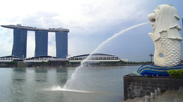SINGAPORE - APR 2nd 2015: The Merlion fountain and Singapore skyline. Merlion é uma criatura mítica com a cabeça de um leão e o corpo de um peixe. É visto como um símbolo da cidade — Fotografia de Stock