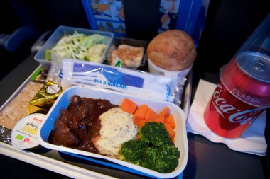 San Francisco, California, ABD - 24 Kasım 2018: Ekonomi sınıfı uçakta salata ve kola ile servis edilen sıcak yiyecekler