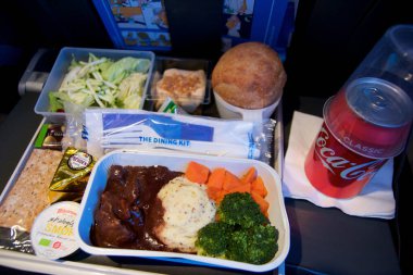 San Francisco, California, ABD - 24 Kasım 2018: Ekonomi sınıfı uçakta salata ve kola ile servis edilen sıcak yiyecekler