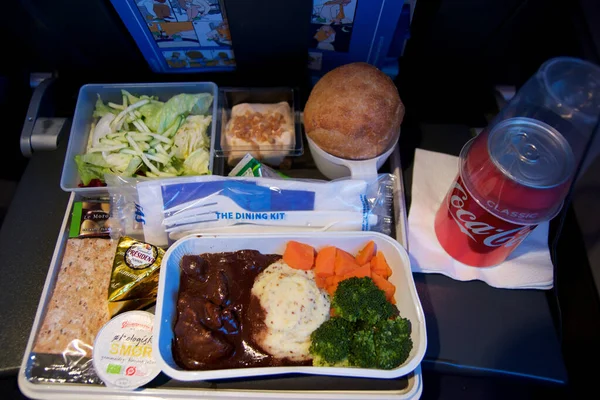 San Francisco, Kalifornien, Vereinigte Staaten - 24.11.2018: Heißes Essen an Bord des Economy Class Flugzeugs auf Tisch mit Salat und Cola — Stockfoto