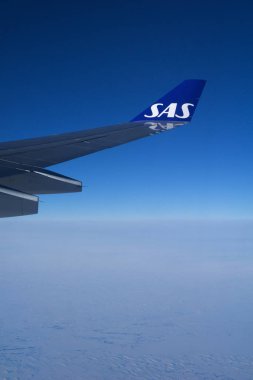 Kopenhag, Danimarka - 24 Kasım 2018: Bulutların üzerinde uçan bir uçağın kanadı