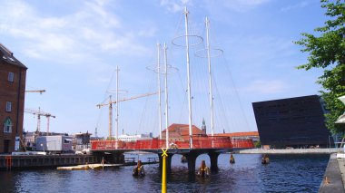 COPENHAGEN, DENMARK - 5 JUL 2015: Kopenhag limanındaki gemi gibi direkleri olan yeni Çember Köprü, Kraliyet Kütüphanesi 'nin uzantısı olan Kara Elmas' a karşı