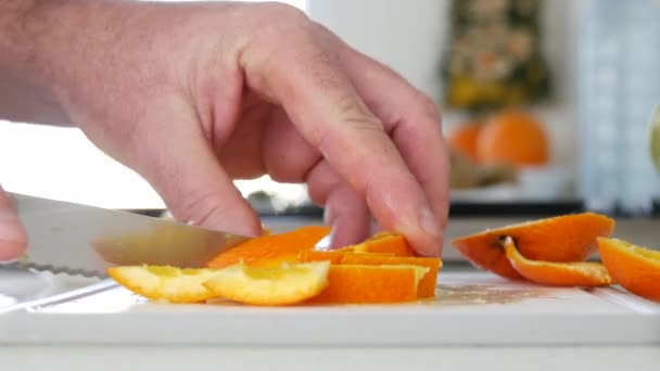 De cerca Hombre corte a mano en rebanadas pequeñas una naranja — Vídeo de stock