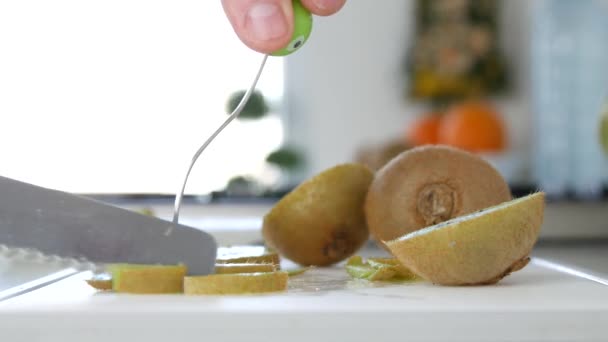 Närbild Man Hand skära i små skivor en Kiwi frukt — Stockvideo