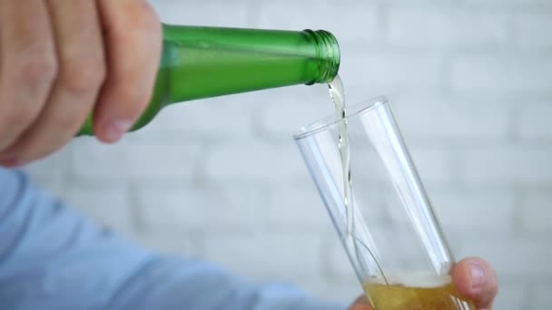 喉が渇いた男が瓶から冷たく新鮮なビールでグラスを満たす — ストック動画
