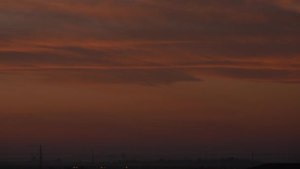 Morgensonnenaufgang an einem Sommertag mit rotem Himmel und wenigen Wolken — Stockvideo