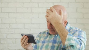 Görüntü: Cep telefonunda Kötü Haber Okurken Hayal kırıklığına uğrayan Adam