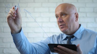 Toplantı odasında elinde tabletle bir iş adamı tahtaya yazı yazıyor.