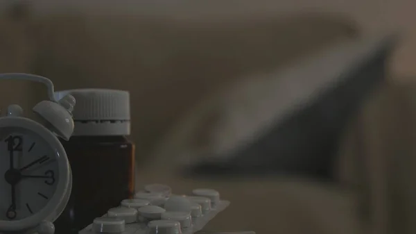 Зображення з нагадуванням годинника та медичними таблетками на столі — стокове фото