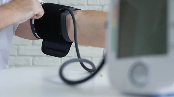 Imagen con un médico usando un dispositivo para tomar presión arterial — Foto de Stock