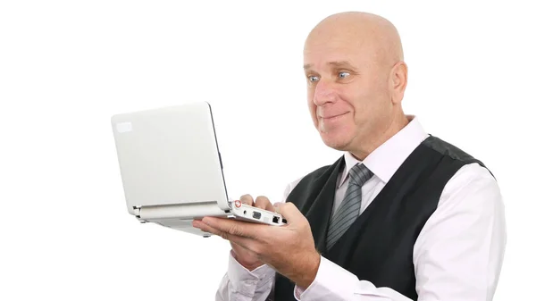 Бизнесмен улыбается и читает удивительные хорошие новости на ноутбуке — стоковое фото