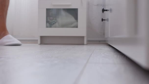 Mannen i sovrummet går med vita tofflor — Stockvideo
