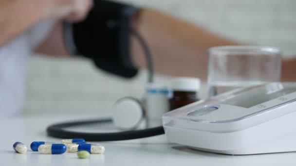 Sufrimiento Persona Compruebe su la presión arterial y tomar píldoras — Vídeo de stock