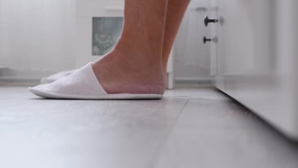 男人带着舒适的拖鞋从床上下来 — 图库视频影像