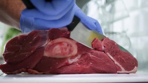 Slager portie vers rundvlees vlees in stukken met een mes — Stockvideo
