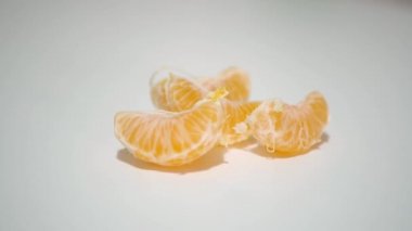 Man Take and Small Lices of Mangerine from the Table