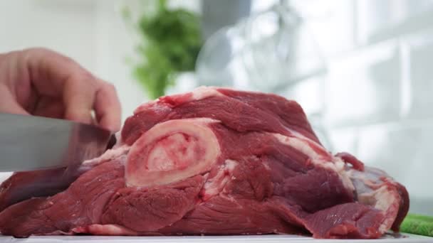 Uomo porzionando carne di manzo fresca e rossa in pezzi con un coltello — Video Stock