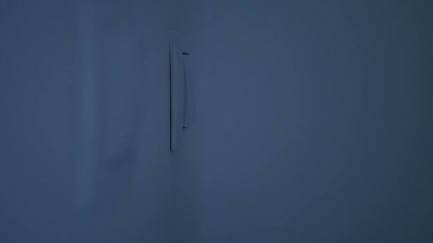 男人从墙上的开关打开办公室的灯 — 图库视频影像
