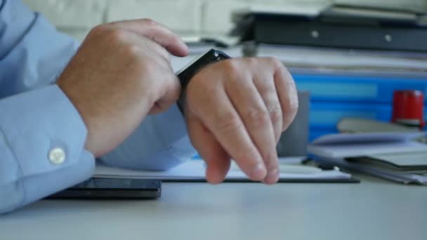 Бизнесмен проверяет папку на своих умных часах в поисках новых сообщений — стоковое видео