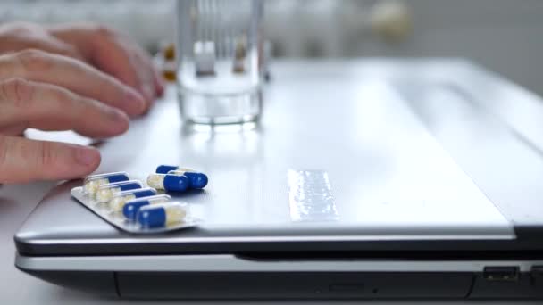 Kranker Mann schaut nervös auf wenige Medikamententabletten aus Laptop — Stockvideo