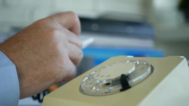 Empresario en la sala de oficina habla con el teléfono y gesticula nervioso con una pluma — Vídeo de stock