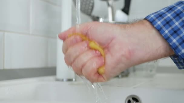 Hand van een Oudere Persoon Spoelen met Water een Schotel Spons in de gootsteen — Stockvideo