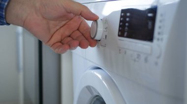 Man Using a Laundry Machine Modern Appliance for Washing and Cleaning Dirty Clothes