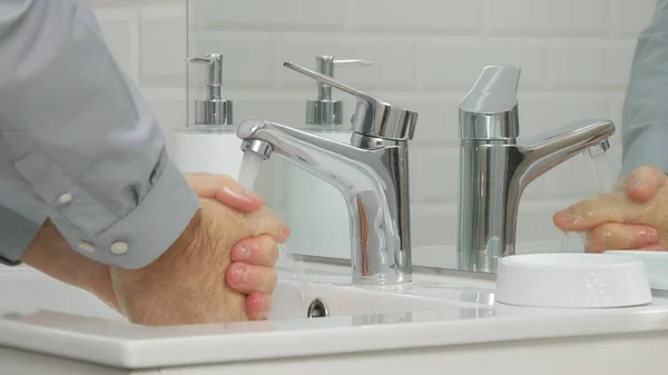 Obrázek s mužem v koupelně Apartmán mytí rukou v keramickém umyvadle — Stock fotografie