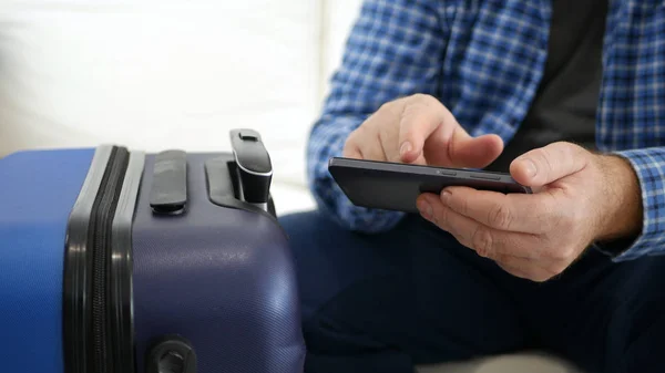 Mann im Urlaubstext mit Mobiltelefon unterwegs, Person mit Smartphone in der Hand wartet auf eine Reise — Stockfoto