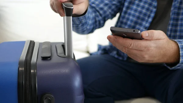 Tourist im Urlaub mit Koffer und Handy in der Hand wartet auf Transport — Stockfoto
