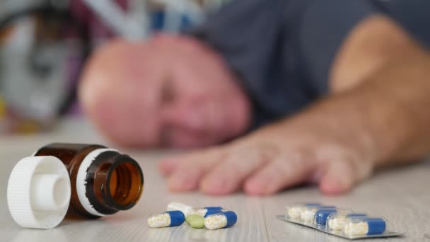Oudere man lijdt aan een hartaanval met medische pillen op de vloer, medische noodsituatie — Stockvideo
