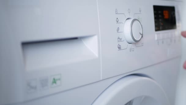 Haushälterin drückt Abschaltknopf und stoppt Waschmaschinentätigkeit — Stockvideo