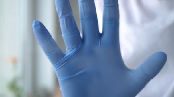 Врач с защитными перчатками в руках делает знак "Стоп" без доступа в зону защиты больницы — стоковое видео