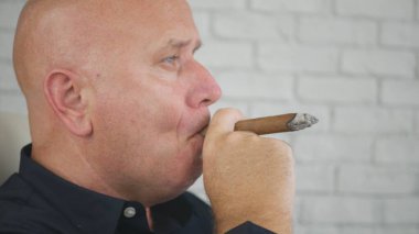 Confident and Relaxed Businessman Portrait Smoking a Black Cuban Cigar