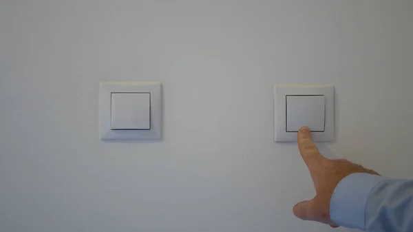 Man Hand Starting the Lights in the Office Pushing the Button from the Wall