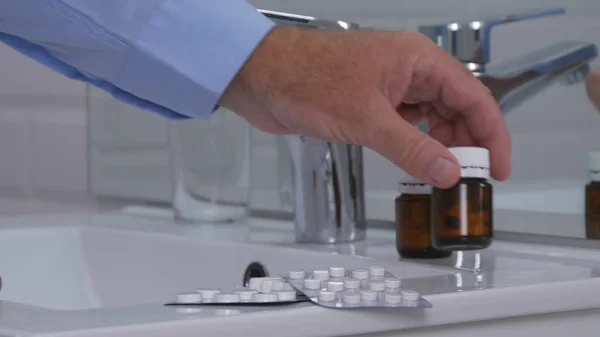Suffering Business Person Taking Pills and Drugs from Bathroom Sink, Elderly Person Suffering a Painful Headache Taking Medicament