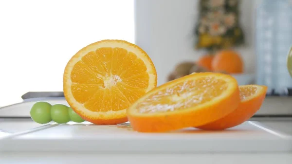 Изображение с фруктовыми ломтиками апельсина на кухонном столе, сладкие органические и здоровые тропические фрукты — стоковое фото