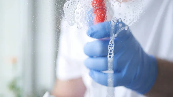 Homem com Luvas de Proteção em Mãos Janela de Limpeza com Detergente de Spray — Fotografia de Stock